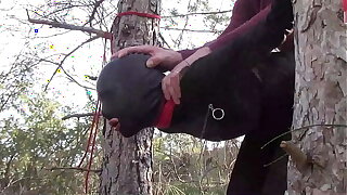 Tied up to a tree open-air on sexy clothes, wearing pantyhose and high ankle boots heels, rough fuck